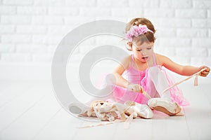 Little child girl dreams of becoming ballerina with ballet shoe