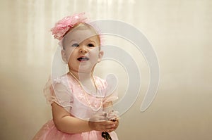 little child girl in elegant pink dress with bow on head on birthday celebration