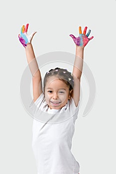 Little child girl with hands painted in colorful paint