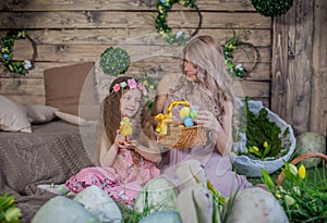 Little child girl and her mother among Easter decoration