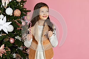 Little child girl holding lollipop candy cane