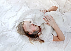 Little child girl hugs her toy in the bed, enjoyng sweet dreams