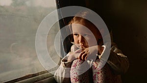 Little child girl looking out of a asian train window