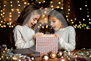 Little child girl opening magic Christmas gift box