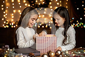 Little child girl opening magic Christmas gift box
