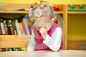 Little child girl playing in kindergarten in Montessori preschool