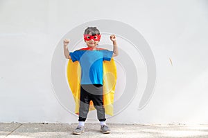 Little child girl plays superhero. Child on the white background. Girl power concept