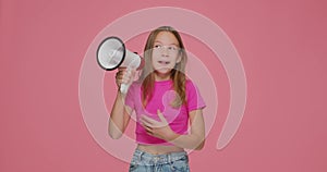 Little child girl scream, speak in megaphone, announce sale on pink background. Children online store advertising