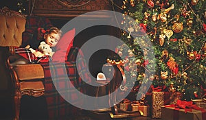 Little child girl sleeping near a Christmas tree
