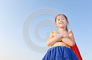 Little child girl Superhero on clear blue sky background. Kid super hero concept