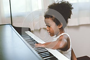 Little child girl touching looking at the piano interested impression with music instrument