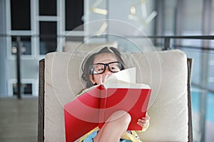 Little child girl wear Glasses reading book in library, Education concept