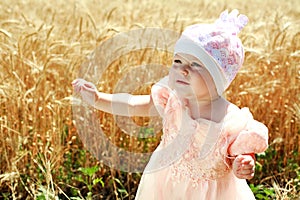 Little child girl wondering in wheat field