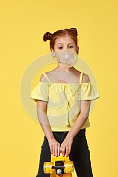 little child girl with yellow skateboard