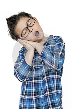Little child in glasses feels sleepy on isolated white background