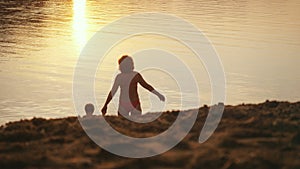 Little child and grandmom going to the sea holding hands during beautiful sunset happy vacation time