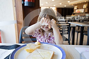 Little child hiding face with ham