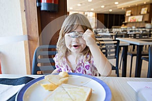 Little child hiding face with spoon