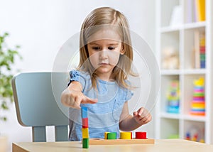 Little child kid playing with building blocks