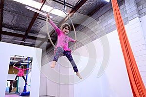 Little child learn circus skills on Aerial Lyra