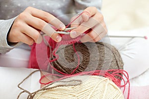 Little child learns to knit.