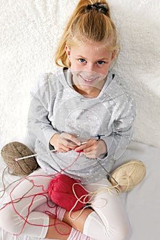 Little child learns to knit.