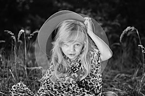 Little child  with long blond hair and hat