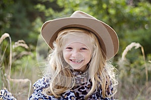 Little child  with long blond hair and hat