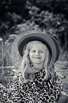 Little child  with long blond hair and hat