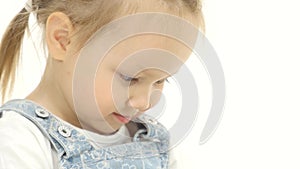 Little child looks interesting pictures on the tablet. White background