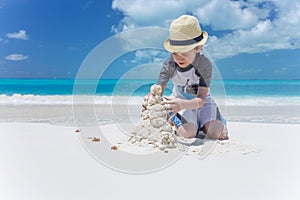 Little child making sand castle at the beach