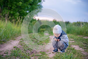 Little child in nature, looking down