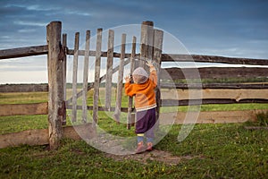 Little child opening  old gates. The storm approaching