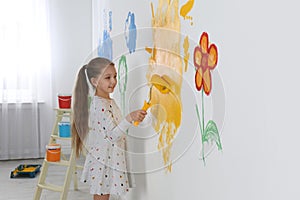 Little child painting wall with roller brush