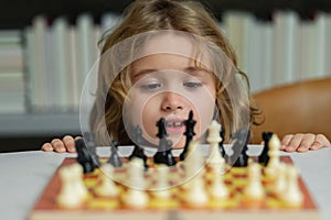 Little child play chess. Kid playing board game. Thinking child brainstorming and idea in chess game. Kids early