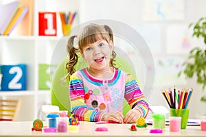 Little child playing with colorful clay