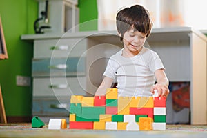 Little child playing with lots of colorful plastic toys at home. educational games at home or in kindergarten