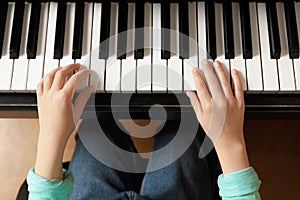 Little child playing piano, above view. Music lesson