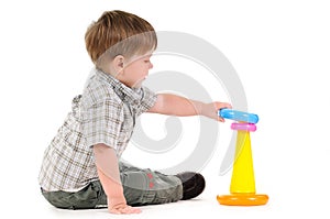 Little child playing with pyramid toy