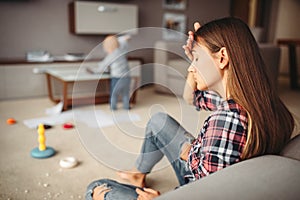 Little child playing in room, mother in stress