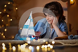 Little child playing with toy ship