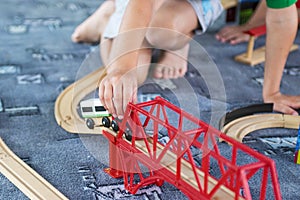 Little child playing with wooden railway on the floor. Little boy playing with wooden train set