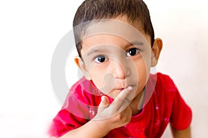 little child putting finger on mouth with small hairs