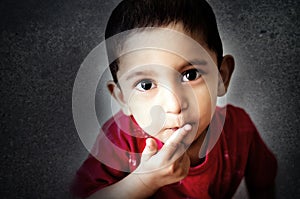 little child putting finger on mouth with small hairs