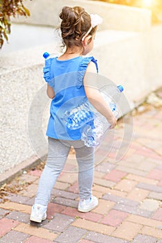 Little child recycling plastic water bottles. World Environment Day.