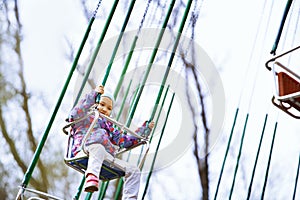 Little child riding on a chaing swing