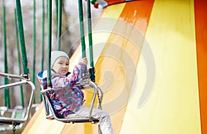 Little child riding on a chaing swing