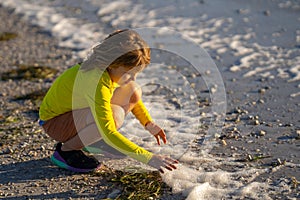 Little child running on the beach on sunrise. Happy amazed kid running on sea beach. Cute child running near ocean on