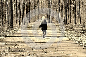 Little child runs along forest road