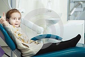 Little child sits in comfortable leather dentist chair